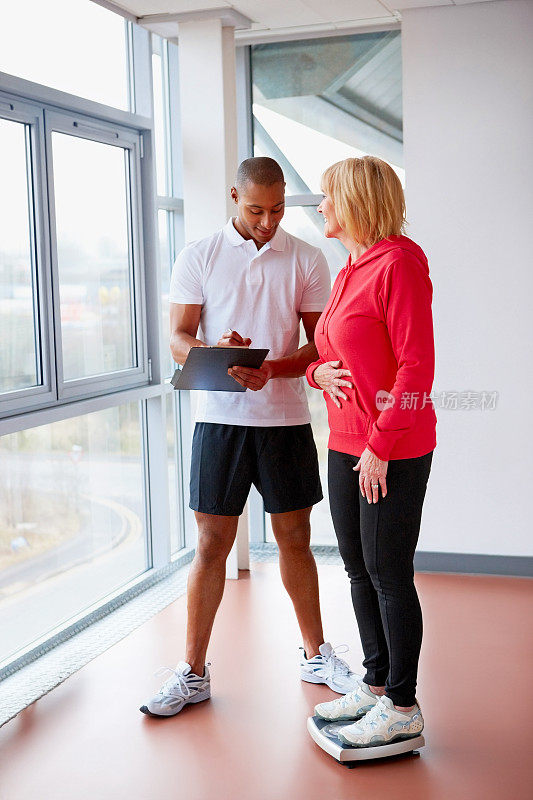 健身教练在健身房检查老年人的健身进度