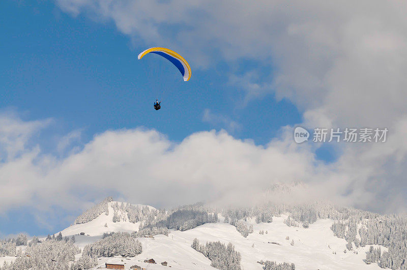 滑翔伞和白雪覆盖的山脉