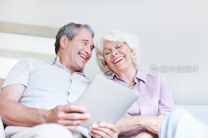 老年夫妇一起使用平板电脑