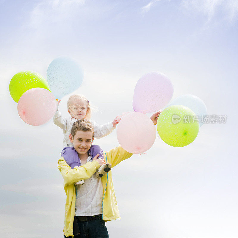 弟弟和他的小妹妹拿着气球