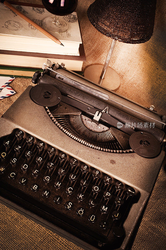 木质书桌上放着一台老式打字机，灯光昏暗