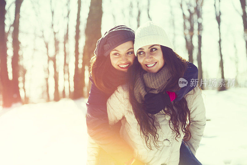 两个女性朋友在雪地里穿过树林