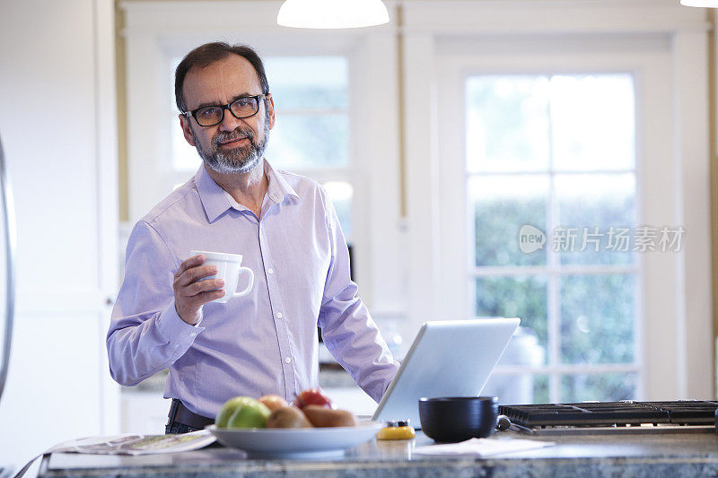 在家工作的西班牙裔商人站在厨房柜台前