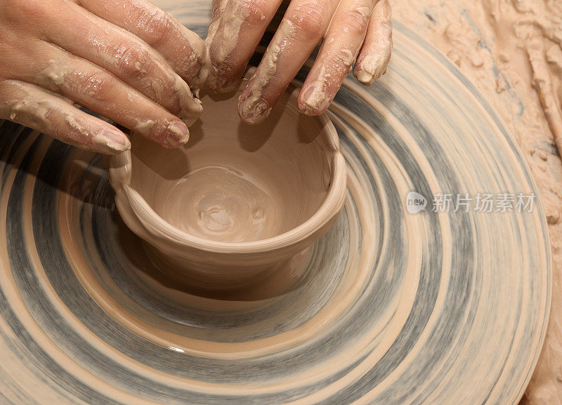 正在陶轮上制作陶碗的妇女
