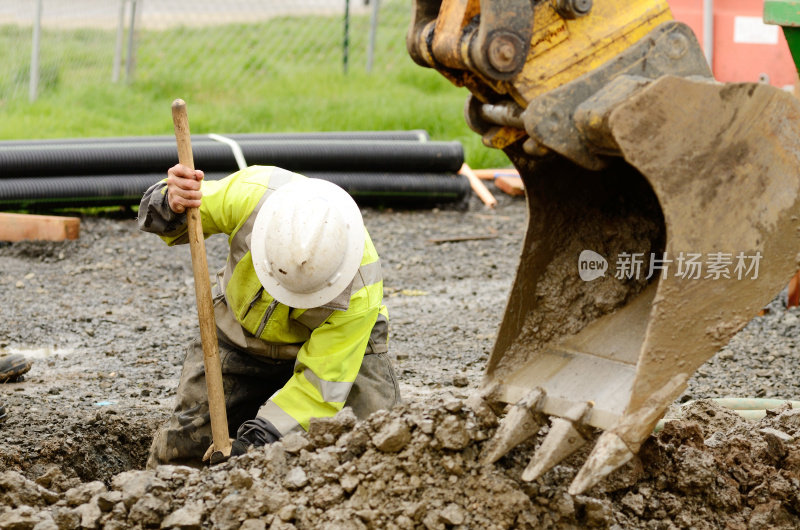 建筑工人在起重机的帮助下挖出泥土