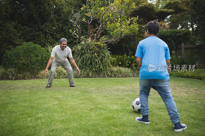男孩和爷爷在公园踢足球