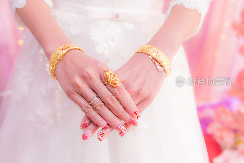 新娘手拿金结婚戒指和手镯