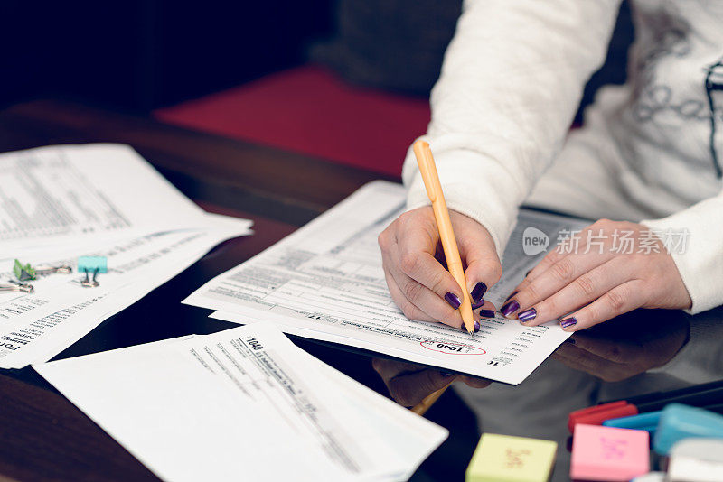 妇女填写税务表格，处理税务文件。1040个人所得税申报表。