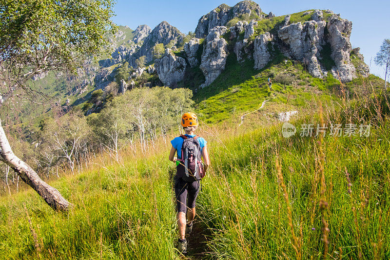 徒步女行走在高山草地上