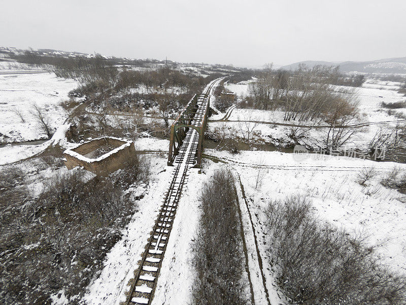 古老的铁路穿越雪域的冬季自然景观。鸟瞰图。