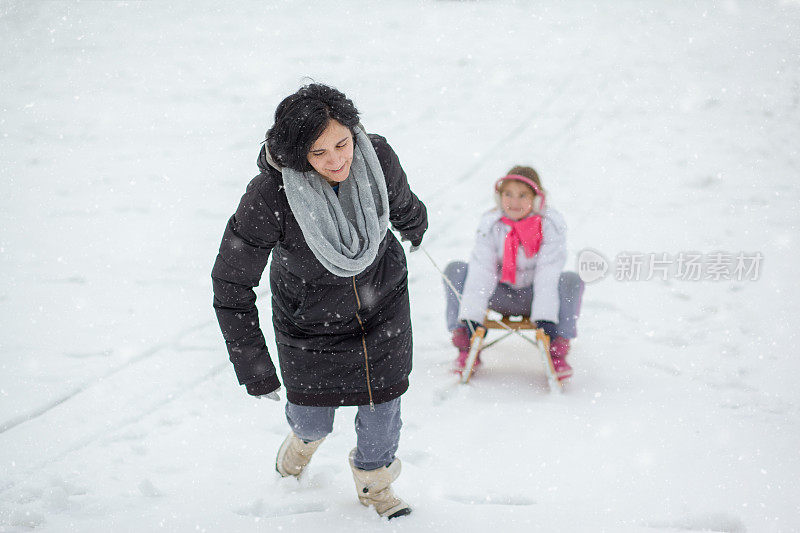 母亲和她的女儿享受雪