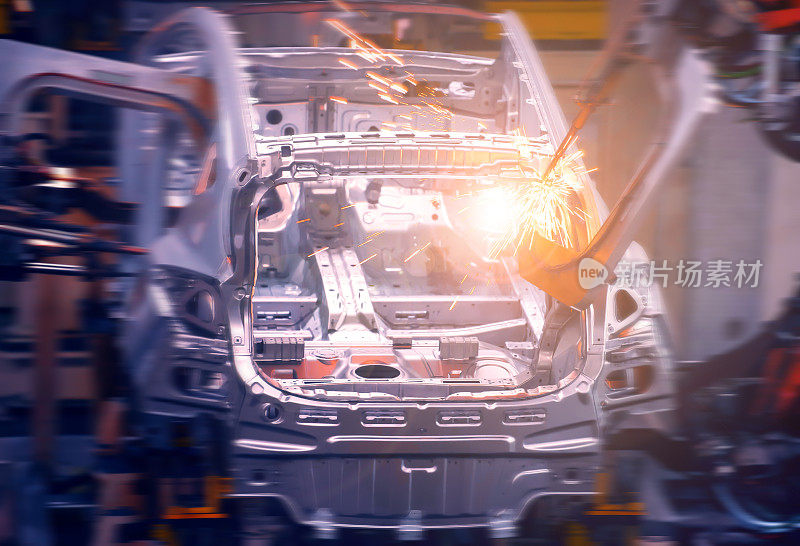 在汽车制造工厂，机器人手臂正在焊接车身焊点，使车身更坚固。