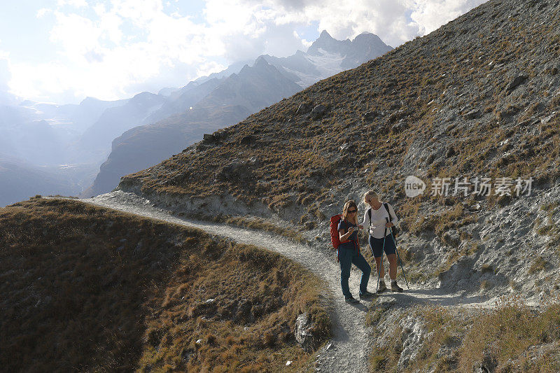 当道路分叉时，两个徒步旅行者在看地图