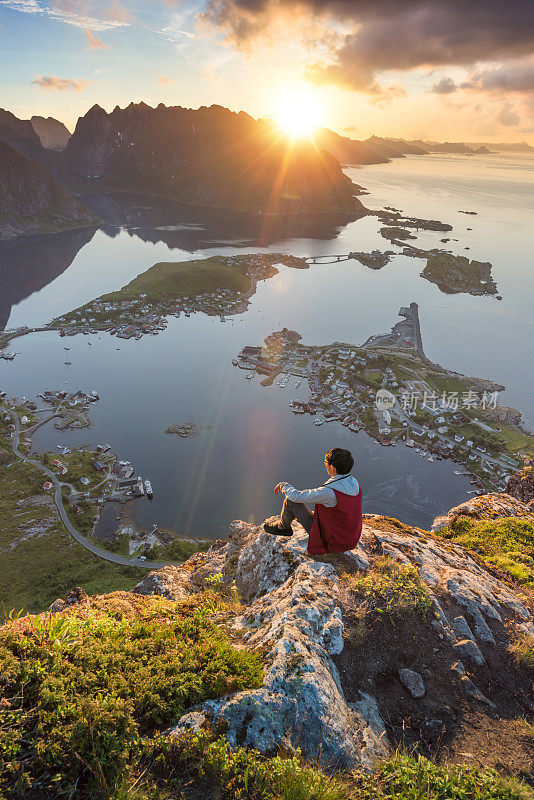 游客欣赏挪威罗浮敦群岛的夏日日落风景