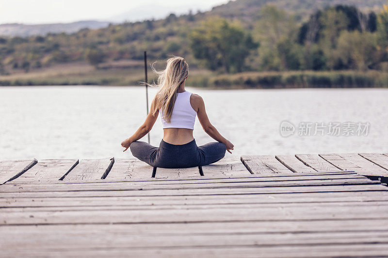 有个漂亮女人在湖边做瑜伽