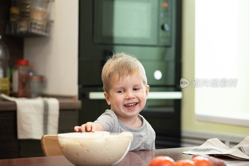 可爱的小男孩在家里厨房做披萨