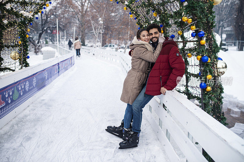 一对相爱的年轻夫妇正在享受冬日溜冰