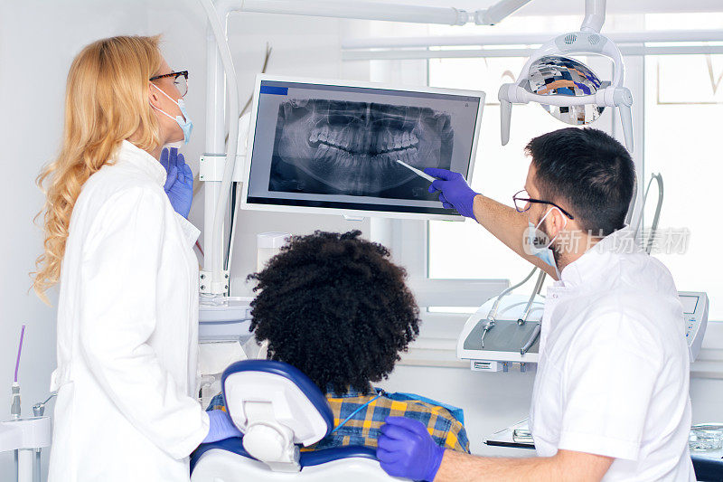 牙医向一位男性病人解释牙齿x光片