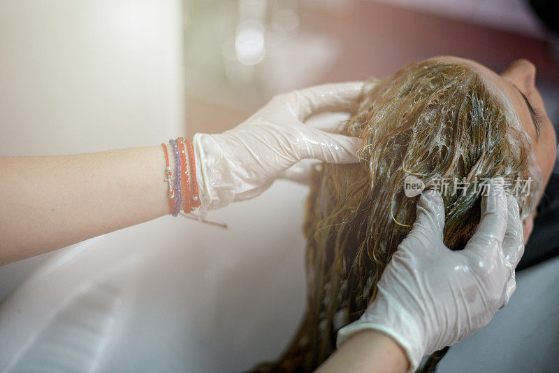女孩正在美发师给她洗头