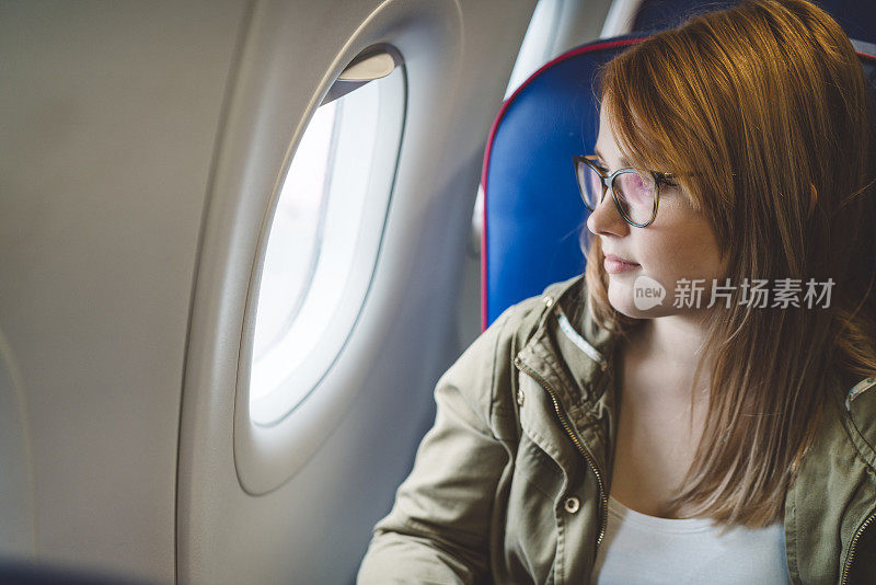 一个女人在飞机上看着窗外