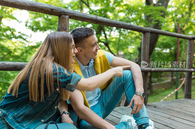 十几岁的女孩在树林里指着她男朋友的东西