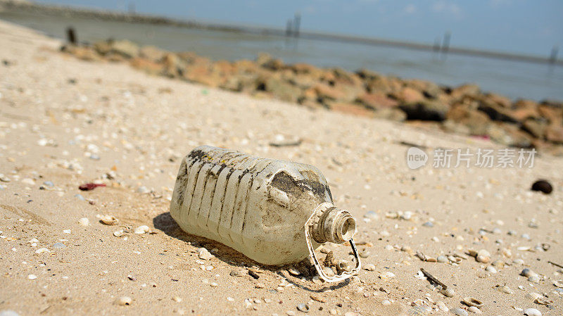 海滩上的垃圾和塑料瓶-海洋环境污染的概念