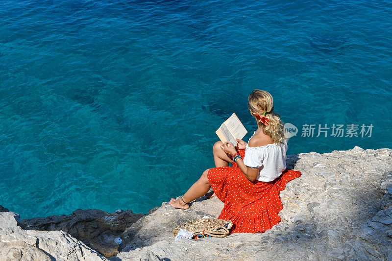 在海边读书的女人。