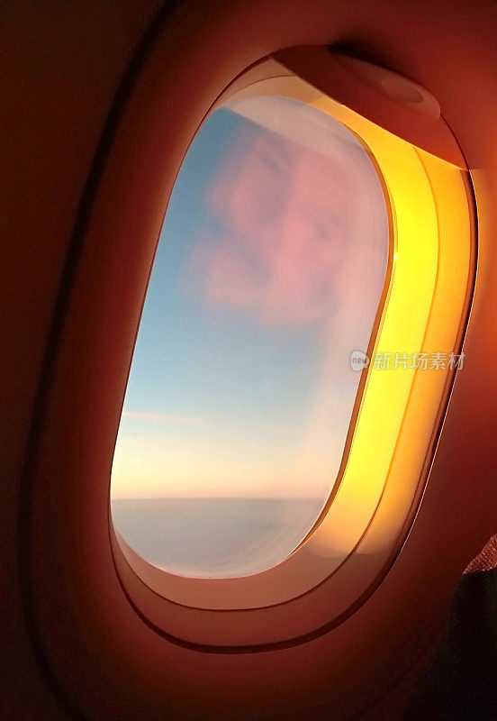飞机的舷窗被橙色的阳光照亮