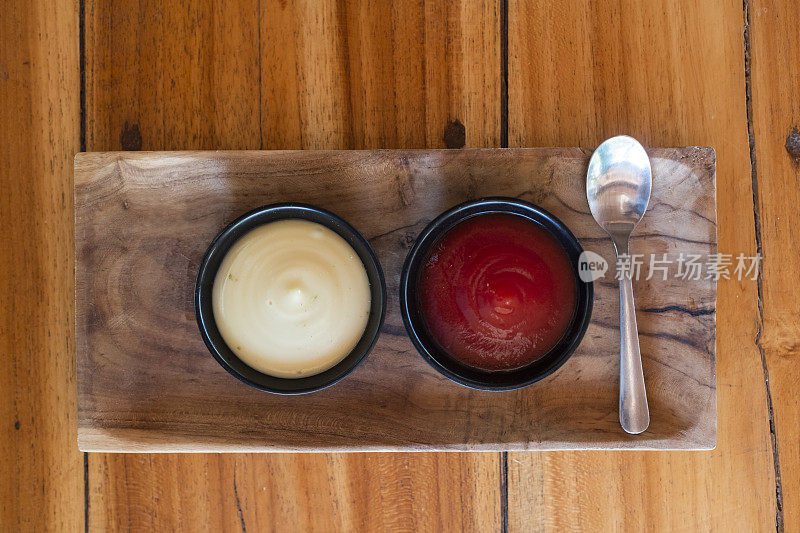 蛋黄酱和番茄酱放在一个木制的碟子上