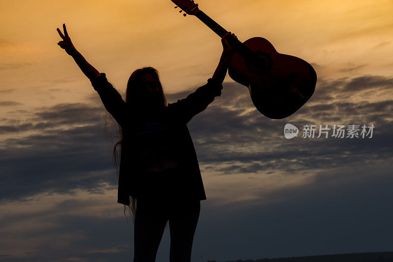 剪影女子在日落弹吉他