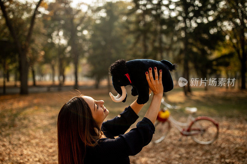 年轻女子在公园玩填充玩具