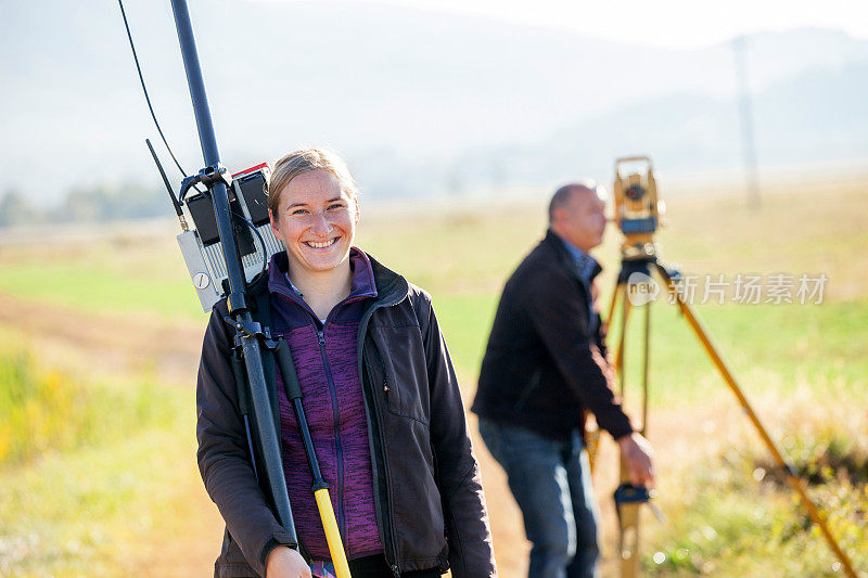 微笑的女性测量师携带GPS工作工具
