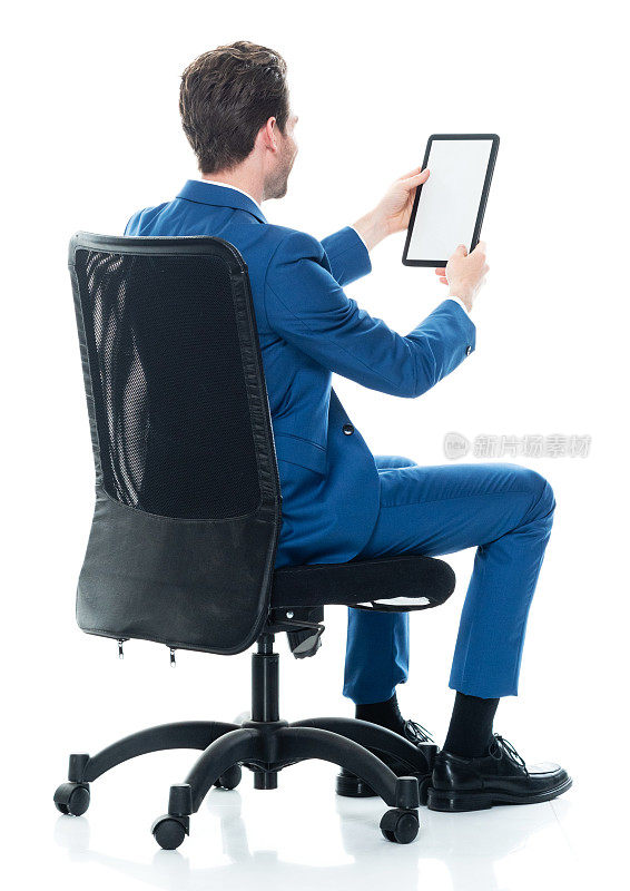 白种年轻男性商人穿着夹克在休息，用着数码平板电脑