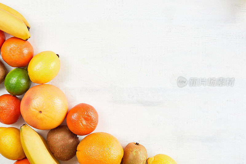 各种新鲜热带水果橙子，橘子，香蕉，葡萄柚，柠檬，酸橙，猕猴桃白色背景。