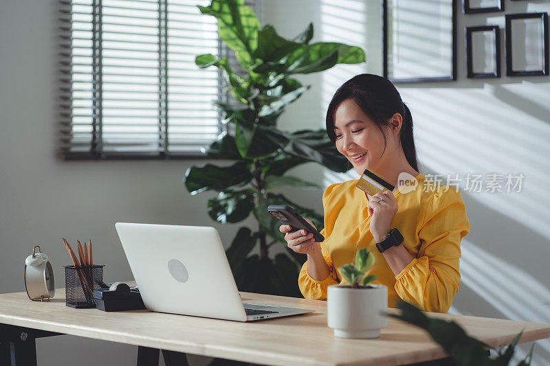 亚洲女性喜欢网上购物，持有信用卡，在家办公时使用智能手机在线支付。