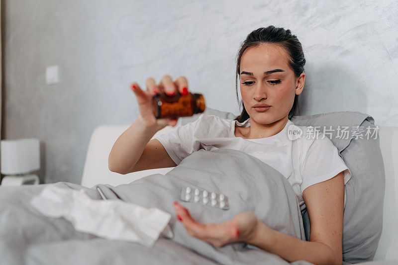 年轻女子在床上吃药