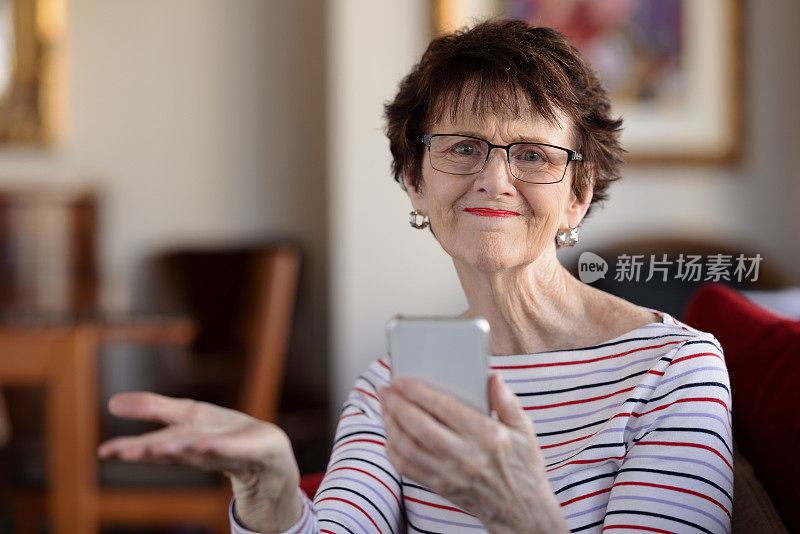 不开心的老年女性在室内拿着手机
