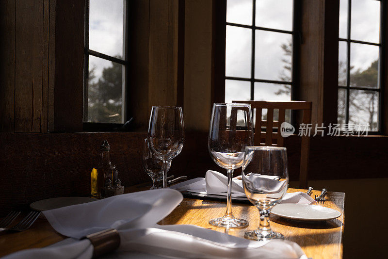 餐厅木桌上的空酒杯、刀叉近景
