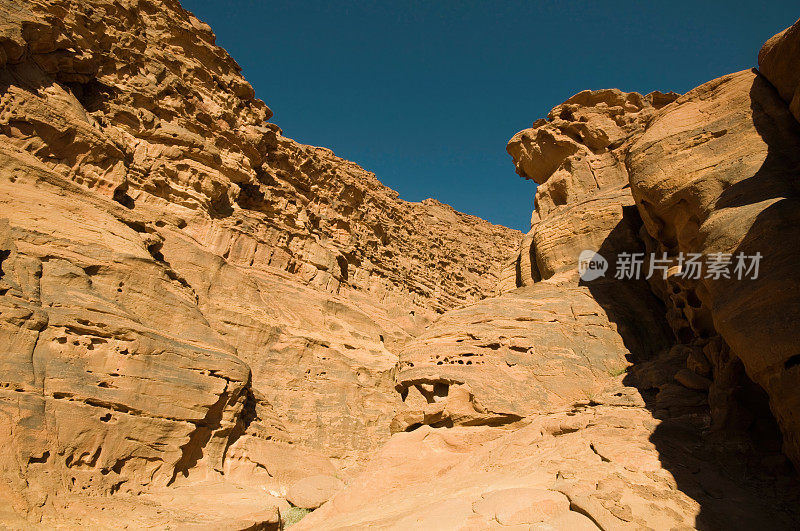 在瓦迪拉姆沙漠的岩层，橙色与蓝色的天空为背景-约旦