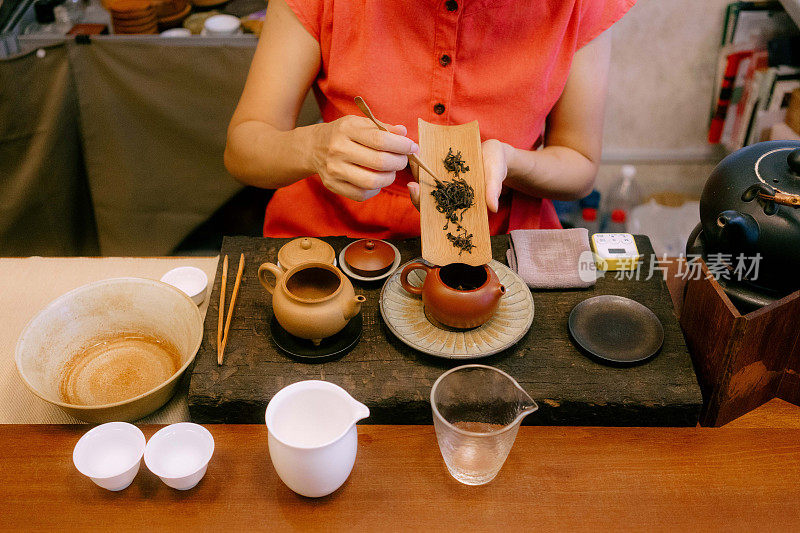 茶艺师用传统的壶和杯泡茶近景