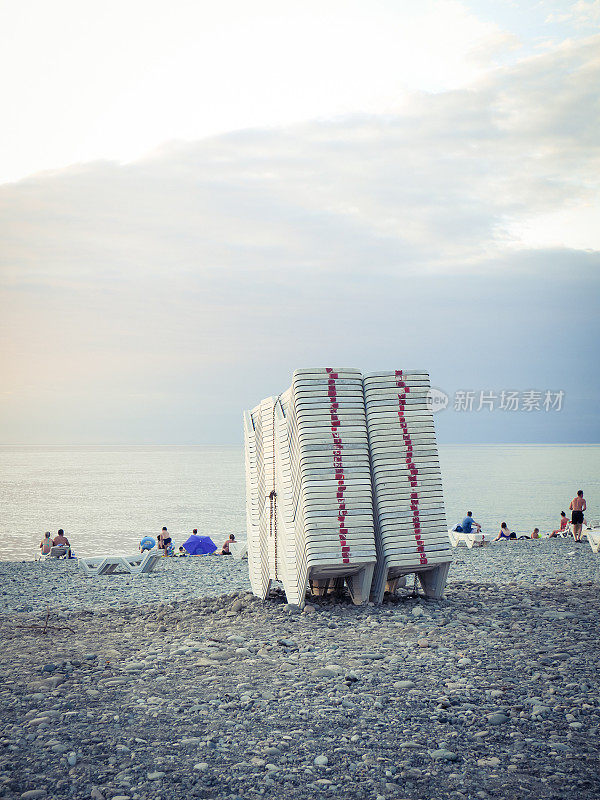 塑料沙滩椅堆放在沙滩上