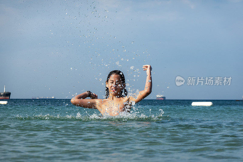 他用手在海里泼水。一个夏天的早晨。忒涅多斯岛。爱琴海北部，12岁的帅哥。长头发的