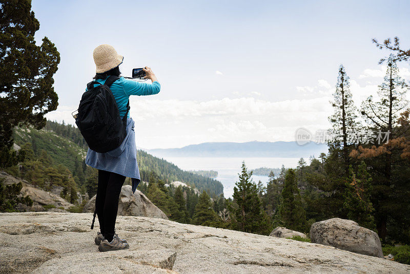 女子用智能手机拍摄翡翠湾。鹰湖小径。翡翠湾。南太浩湖。加州。