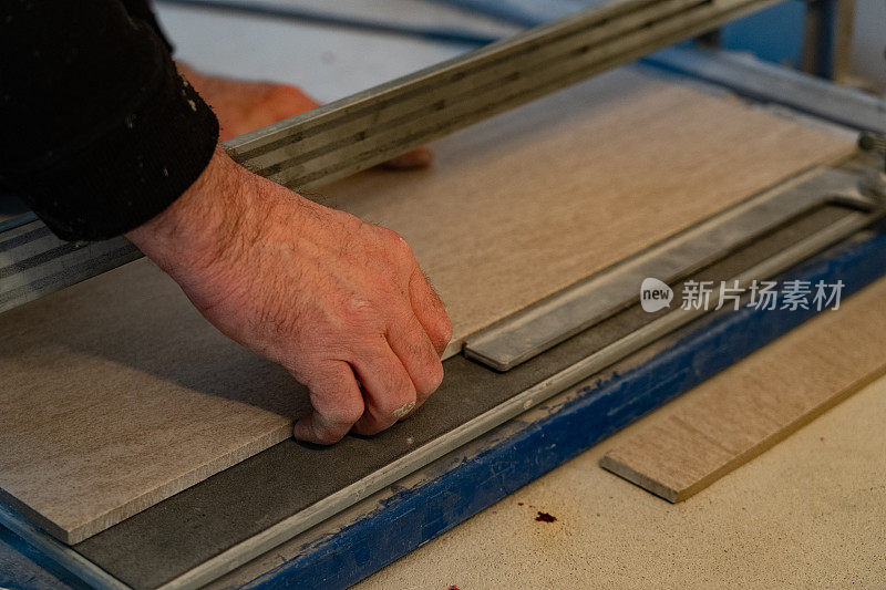 一个男人正在用瓷砖切割机切割瓷砖