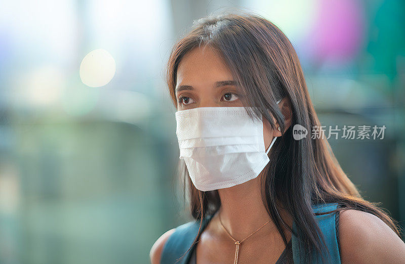 在疫情紧急情况下，美丽的亚洲女性在户外戴着口罩。