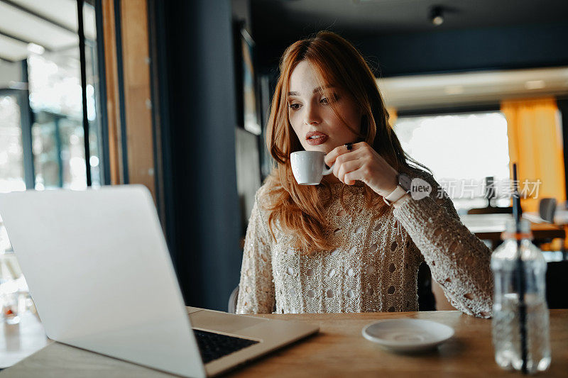女性自由职业者一边喝咖啡一边查看每日在线任务