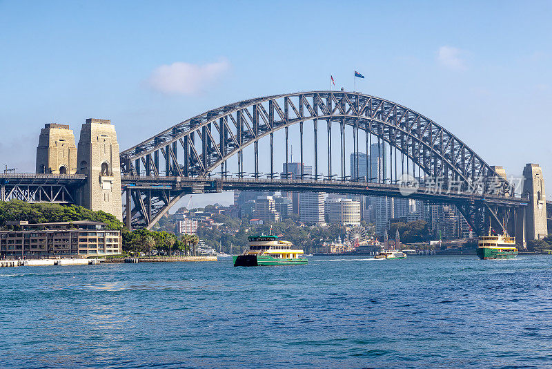 标志性的悉尼海港大桥，载客渡轮在海湾之间来回穿梭。一座连接中央商务区与北岸的拱桥。