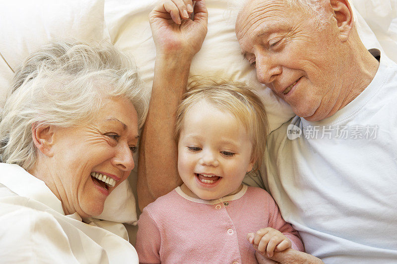 爷爷奶奶在床上拥抱孙女