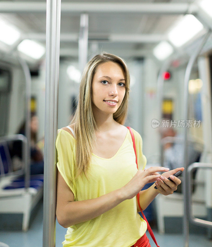 地铁里拿着智能手机的女孩