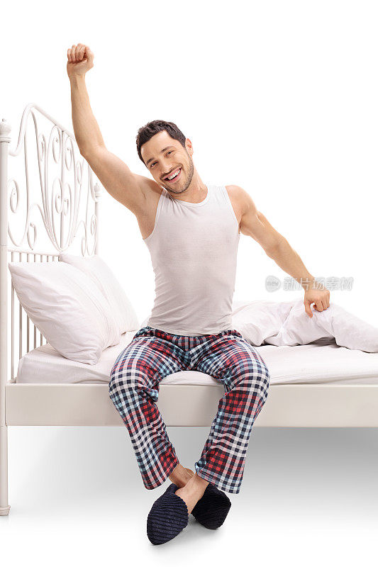 穿着睡衣的男人坐在床上伸懒腰
